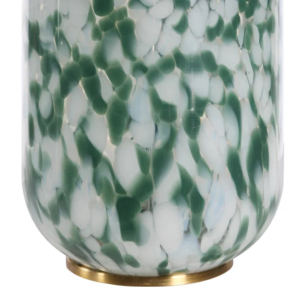 A close-up of a decorative glass vase with a green and white marbled pattern and a gold metal base.